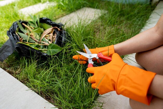 Una giovane donna si prende cura del giardino e taglia l'erba