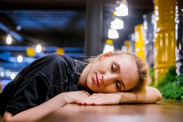 Una giovane donna si siede a un tavolo in un caffè con uno sguardo pensieroso Si mette la testa tra le mani