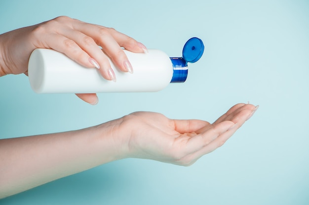 Una giovane donna si versa nella mano un gel antibatterico