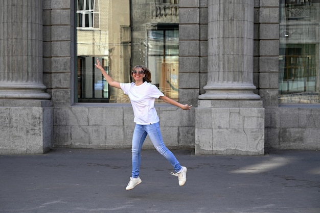 Una giovane donna sicura di sé cammina per le strade della città, una donna sorride e si gode la vita