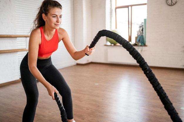 Una giovane donna sportiva si allena attivamente in un fitness club utilizza attrezzature sportive