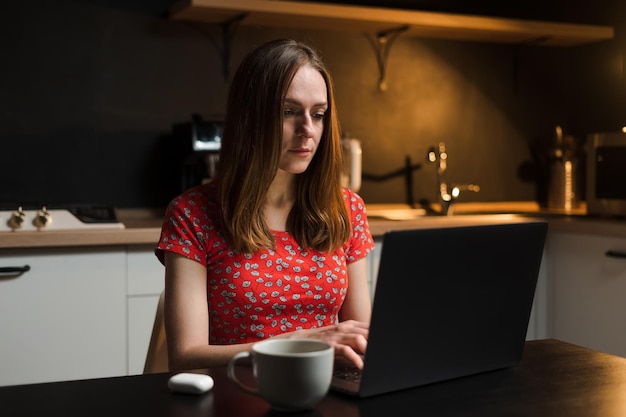 Una giovane donna sta lavorando in cucina Lavoro straordinario Libero professionista lavora da casa