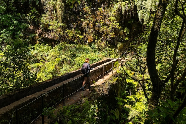 Una giovane donna su un ponte sul sentiero Levada do Caldeirao Verde Queimadas Madeira