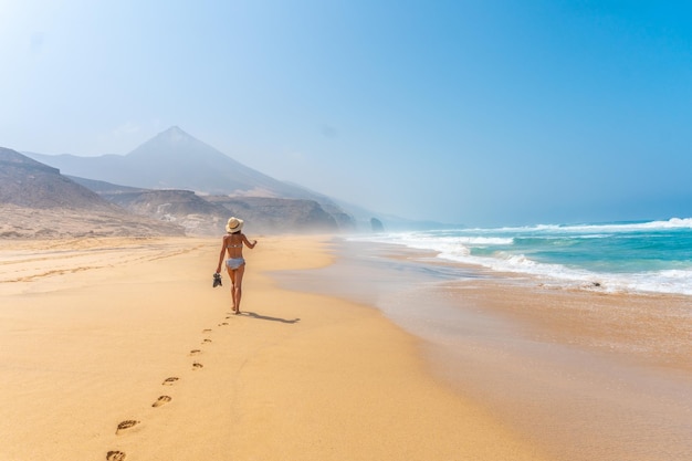 Una giovane donna sulla spiaggia selvaggia Cofete del parco naturale di Jandia Fuerteventura