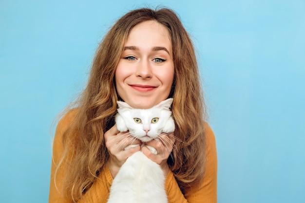 Una giovane donna tiene in braccio un gatto bianco.