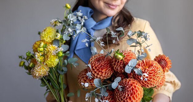 Una giovane donna tiene un mazzo di fiori di crisantemi.