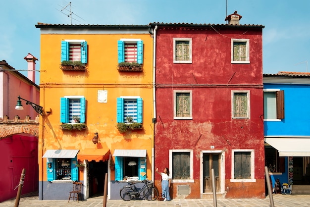 Una giovane donna turistica per le strade colorate di Burano a Venezia mentre sorride e visita la città italiana