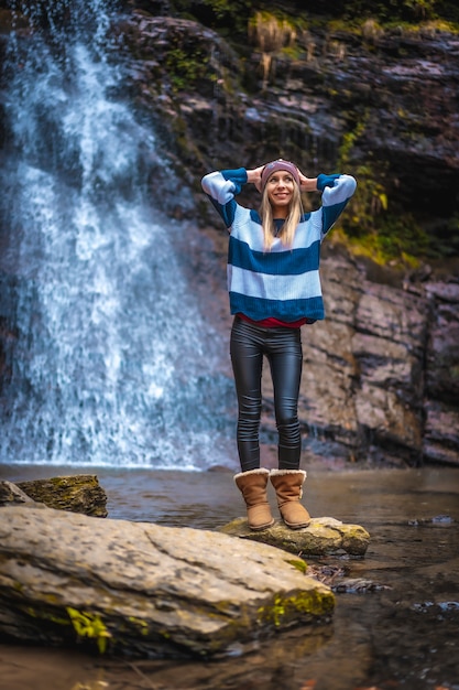 Una giovane donna vicino a una cascata