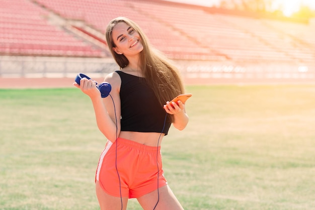 Una giovane e bella atleta in abbigliamento sportivo si sta allenando allo stadio.