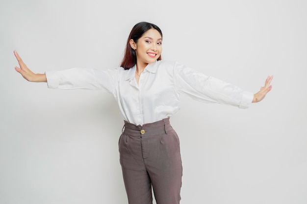 Una giovane e bella donna asiatica si sta allungando dopo il lavoro isolato su sfondo bianco