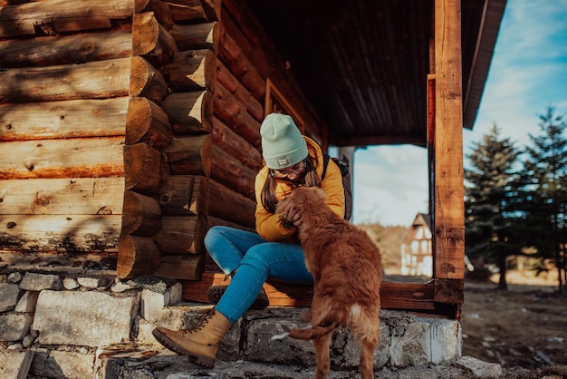 una giovane e bella ragazza sta giocando con il suo cane al cottage