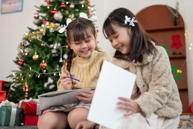 Una giovane e carina ragazza asiatica si diverte a parlare con la sorella minore mentre si diverte a Natale