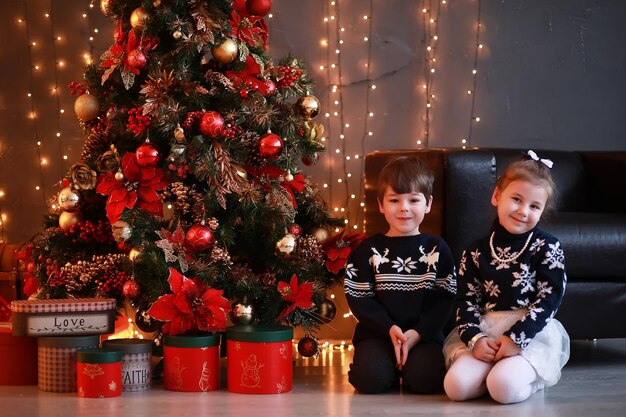 Una giovane famiglia con bambini decora la casa per le vacanze di Capodanno Aspettando il nuovo anno