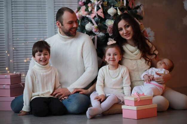 Una giovane famiglia con bambini decora la casa per le vacanze di Capodanno Aspettando il nuovo anno