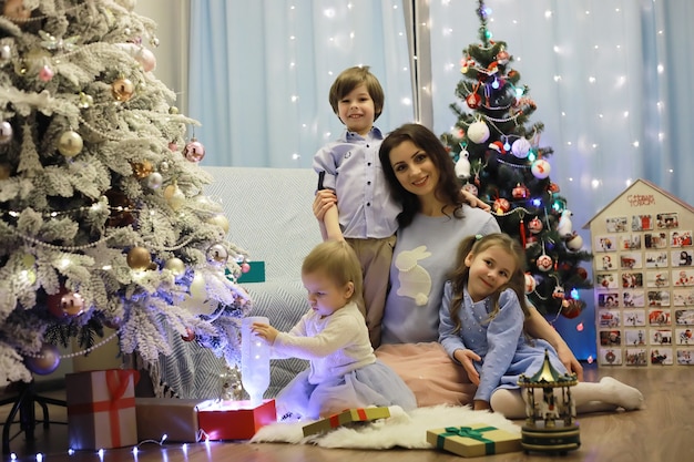 Una giovane famiglia con bambini decora la casa per le vacanze di Capodanno