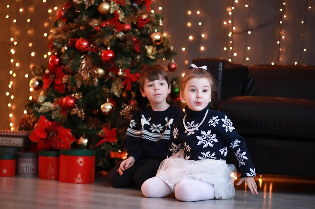 Una giovane famiglia con bambini decora la casa per le vacanze di Capodanno