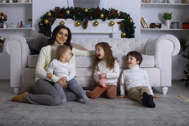 Una giovane famiglia con bambini decora la casa per le vacanze. Vigilia di Capodanno. Aspettando il nuovo anno.