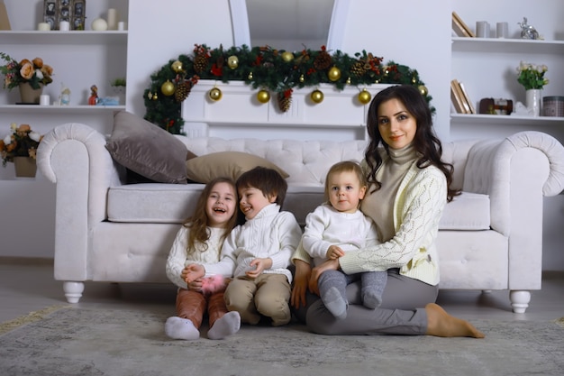 Una giovane famiglia con bambini decora la casa per le vacanze. Vigilia di Capodanno. Aspettando il nuovo anno.