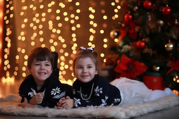 Una giovane famiglia con bambini decora la casa per le vacanze. Vigilia di Capodanno. Aspettando il nuovo anno.