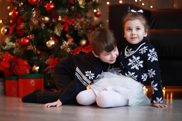 Una giovane famiglia con bambini decora la casa per le vacanze. Vigilia di Capodanno. Aspettando il nuovo anno.