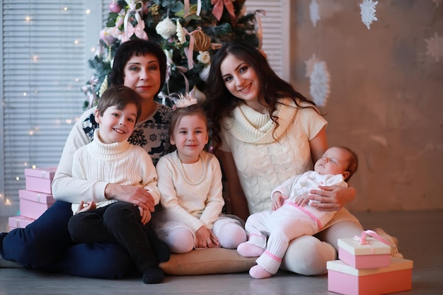 Una giovane famiglia con bambini decora la casa per le vacanze. Vigilia di Capodanno. Aspettando il nuovo anno.