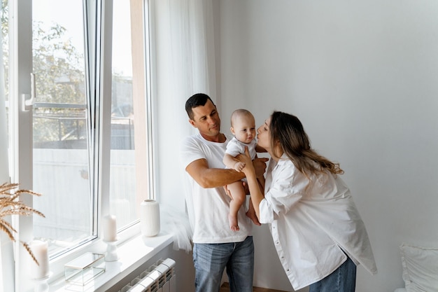 una giovane famiglia con un bambino alla finestra