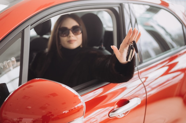 Una giovane imprenditrice sta testando le auto in un negozio di auto