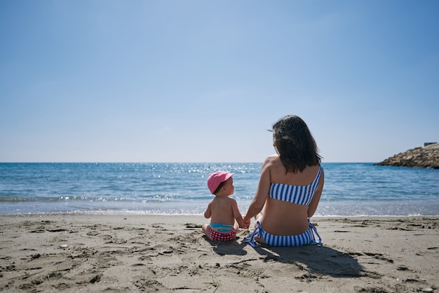 Una giovane madre con il suo bambino in riva al mare