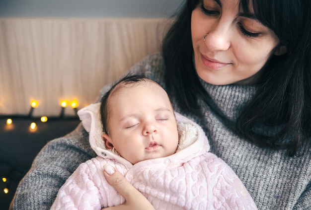 Una giovane madre con una neonata tra le braccia