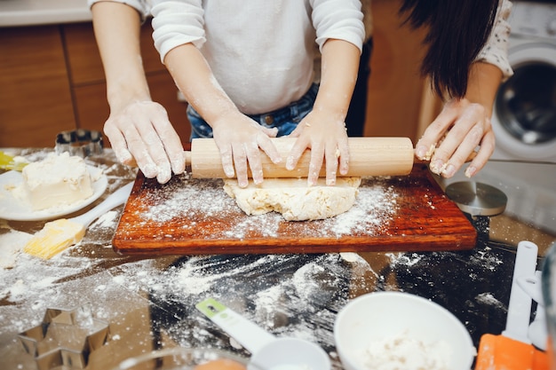 una giovane madre sta preparando il cibo a casa in cucina con il suo piccolo figlio