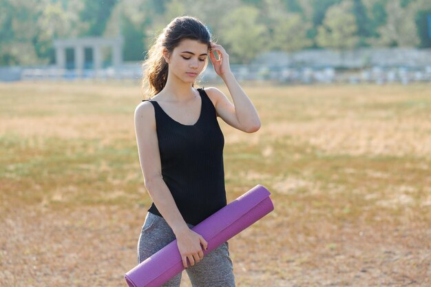 Una giovane ragazza atletica esile in abiti sportivi esegue una serie di esercizi Fitness e stile di vita sano