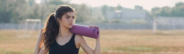 Una giovane ragazza atletica snella in abbigliamento sportivo con stampe di pelle di serpente esegue una serie di esercizi Riposando dopo la pratica dello yoga