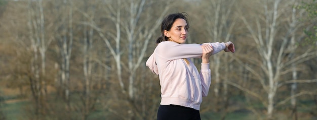 Una giovane ragazza atletica snella in abbigliamento sportivo esegue una serie di esercizi Fitness e stile di vita sano