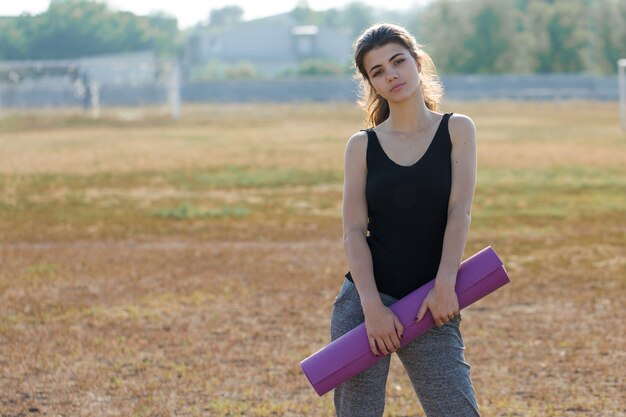 Una giovane ragazza atletica snella in abiti sportivi con stampe in pelle di serpente esegue una serie di esercizi