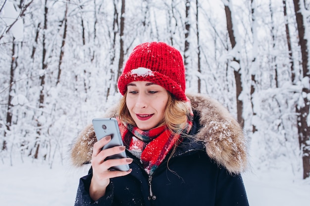 Una giovane ragazza cammina in una foresta invernale innevata