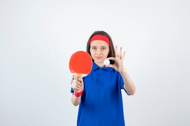 una giovane ragazza con palla con racchetta da ping pong