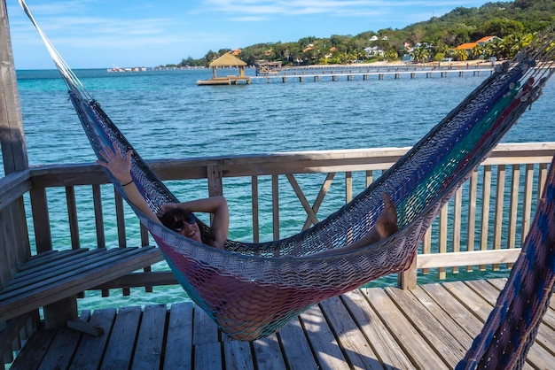 Una giovane ragazza in un'amaca nel Mar dei Caraibi sull'isola di Roatan in Honduras