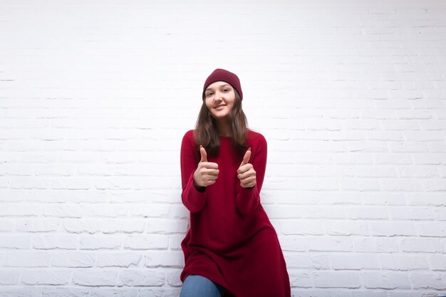 Una giovane ragazza piuttosto sorridente tiene tra le mani una tela bianca bianca