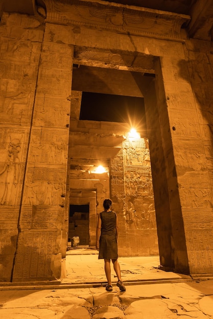 Una giovane ragazza tra le colonne di notte del tempio di Kom Ombo