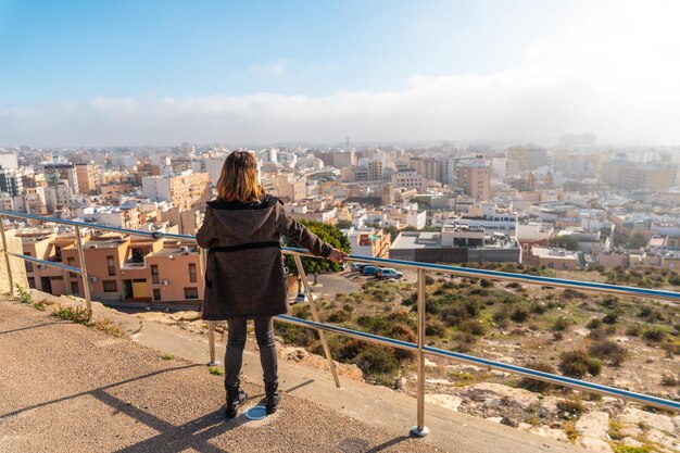 Una giovane ragazza turistica che guarda la città dal punto di vista del Cerro San Cristobal nella città di Almeria, in Andalusia. Spagna. Costa del Sol nel Mar Mediterraneo