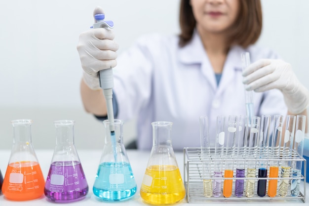 Una giovane ricercatrice, medico, scienziato o assistente di laboratorio che lavora con tubi medici di plastica per ricercare, esaminare esperimenti scientifici in un laboratorio moderno. Istruzione foto d'archivio