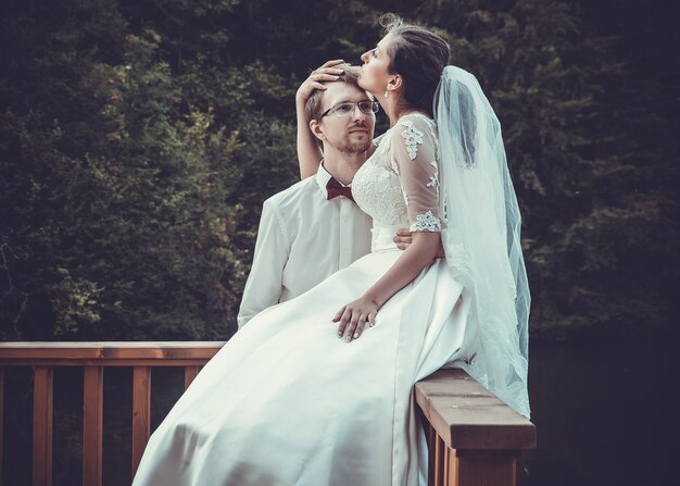 Una giovane sposa e lo sposo in piedi insieme all'aperto, estate