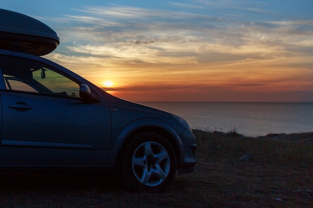 Una gita al mare in macchina. auto sulla spiaggia al tramonto