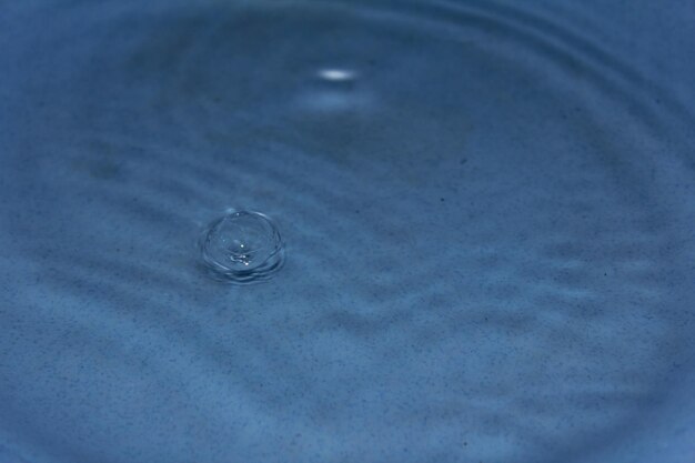 Una goccia d'acqua è in una ciotola blu con sopra una goccia.