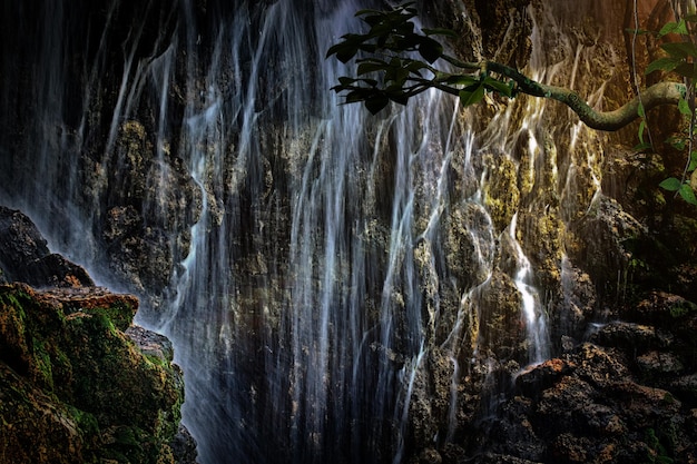 Una grande cascata nella giungla fatata misteriosa tropicale dei raggi del sole