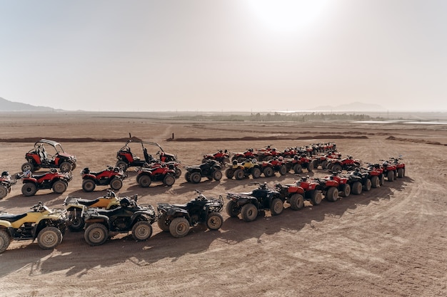 Una grande coda di ATV e passeggini sta nel mezzo di un deserto sabbioso