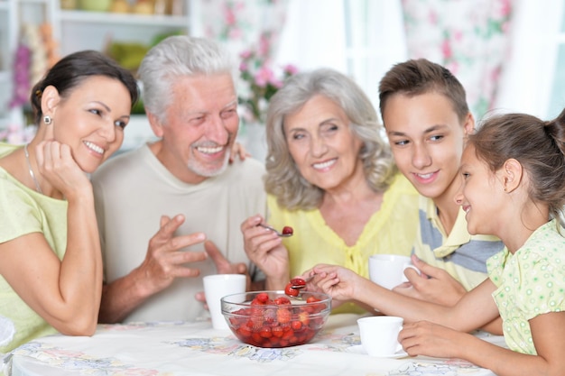 Una grande famiglia felice che mangia.