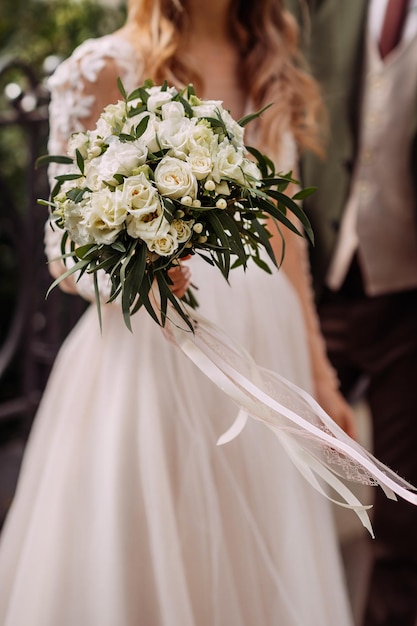 Una grande foto di un bouquet da sposa nelle mani della sposa 4368