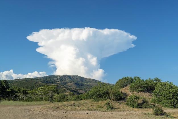 Una grande nuvola bianca a forma di fungo sopra le montagne. Crimea. Choban-kule.