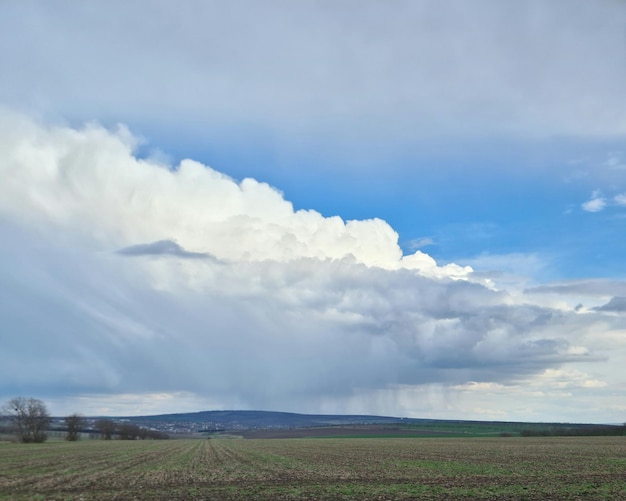 Una grande nuvola nel cielo è sopra un campo.